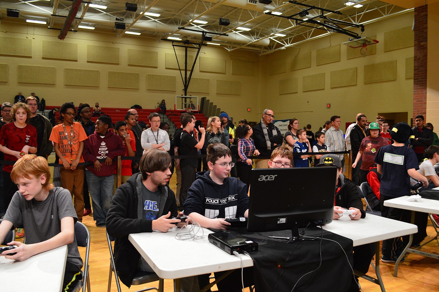 Live photo of students focused on their games as people watch between them