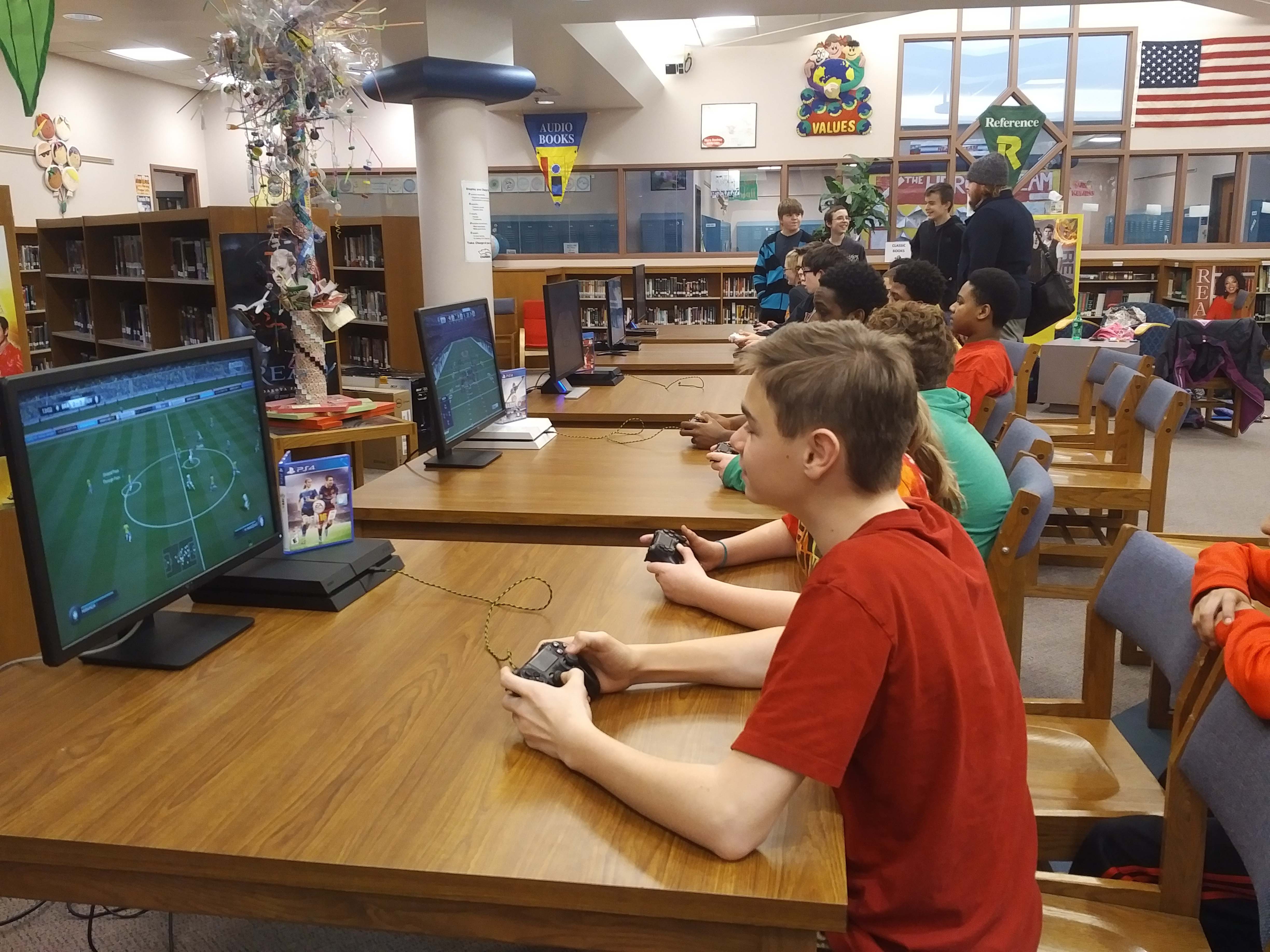 Kids competing in the soccer video game FIFA